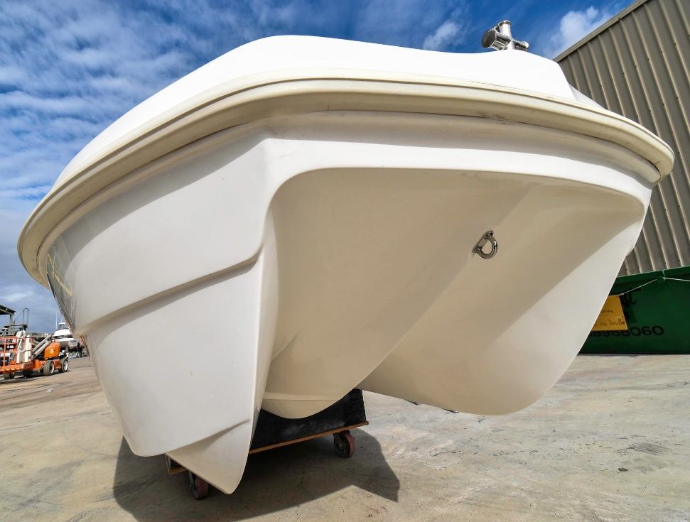 A White Boat is Sitting on a Trailer in Front of a Building — Sandy Straits Marine In Bundaberg, QLD