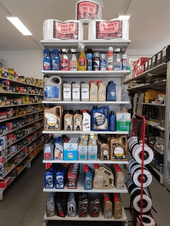 Scomparto di fine corsia del supermercato con sacchi di cibo per animali, lattine e prodotti per la casa impilati sugli scaffali.