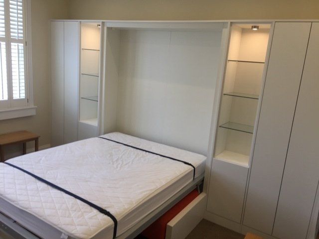 A bedroom with a bed , chair , tub , mirror and television.