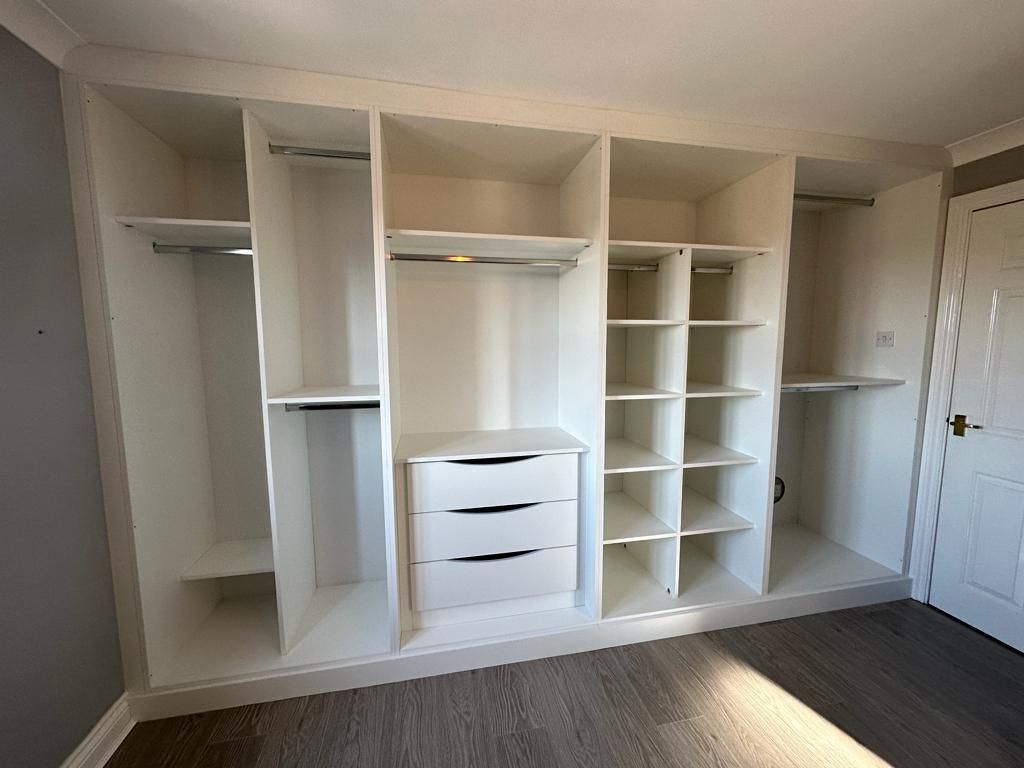 There are many shelves and drawers in the closet.
