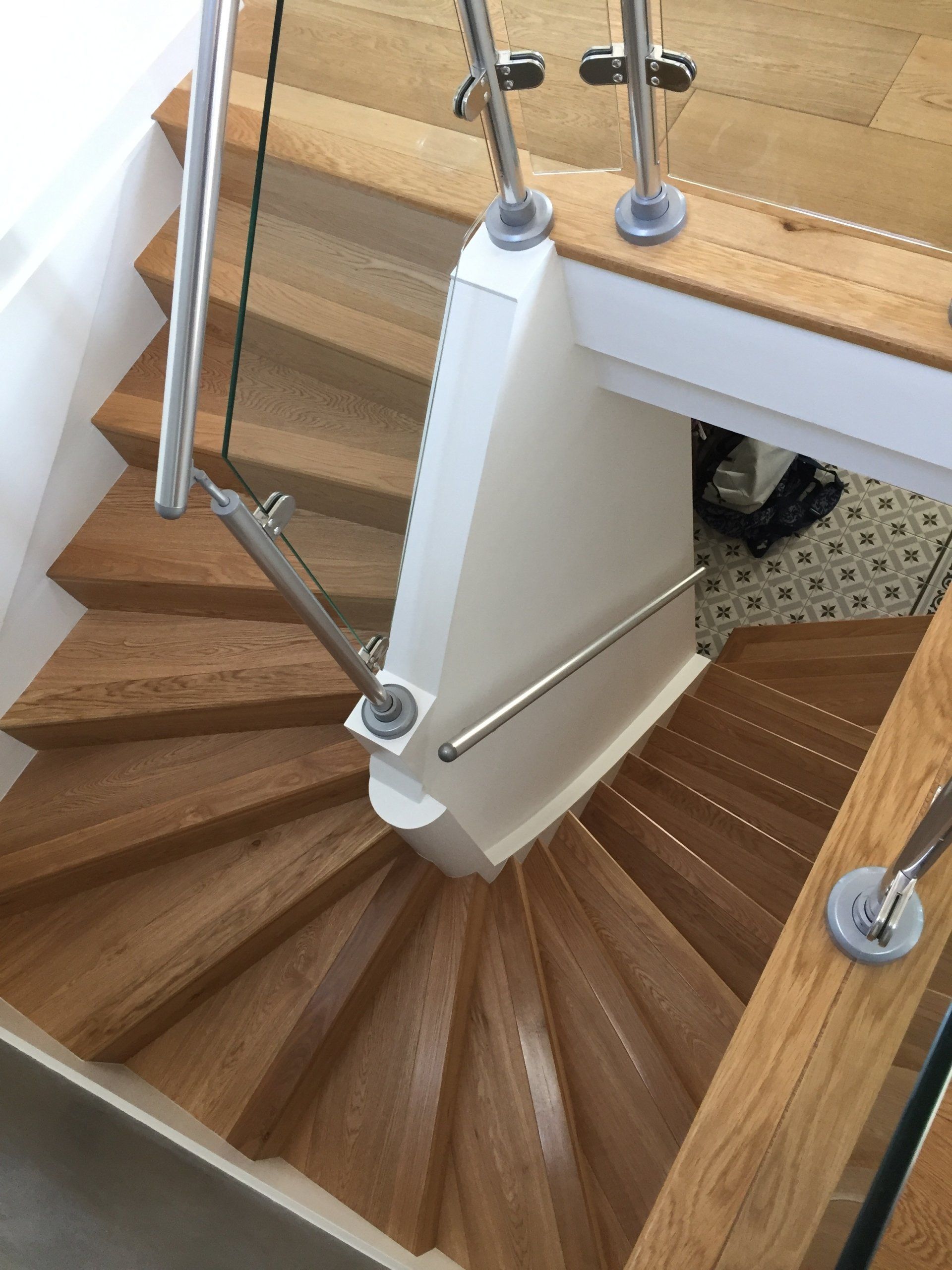 A wooden spiral staircase with a glass railing