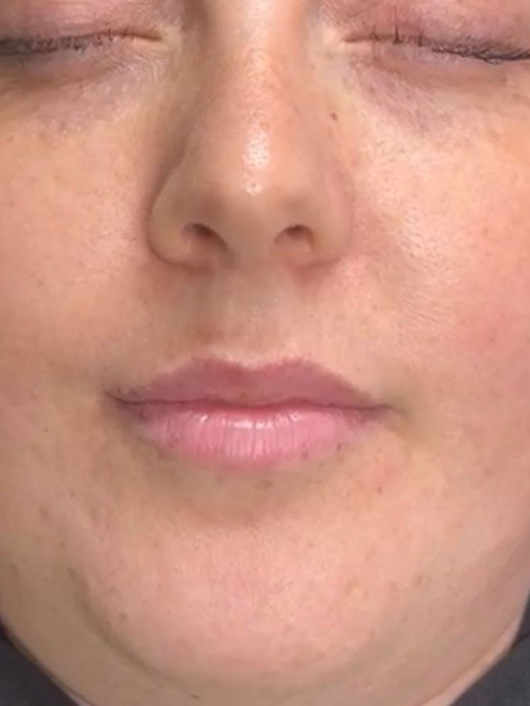 Close-up of a neutral face with eyes closed and pink lips