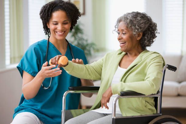 A nurse is helping an elderly woman in a wheelchair with exercises.
