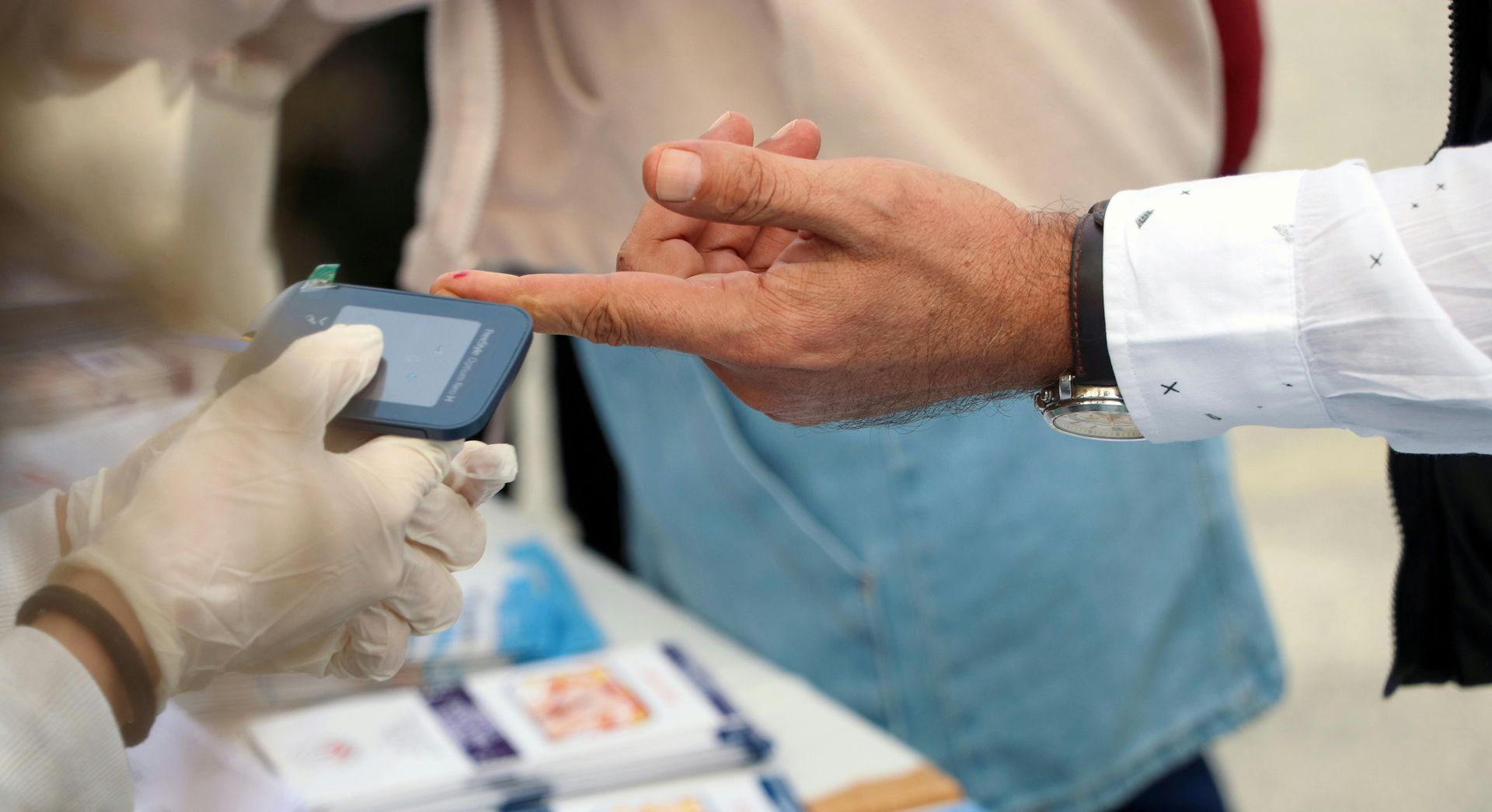 picture of Healthcare provider checking a patient’s blood glucose level 