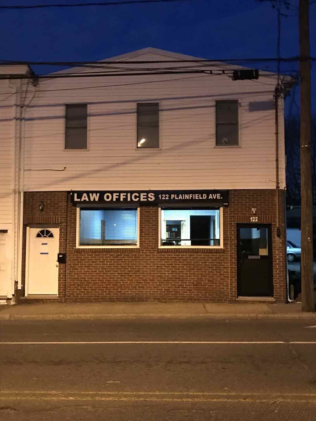 Law offices storefront at dusk, brick building with lit windows and street view
