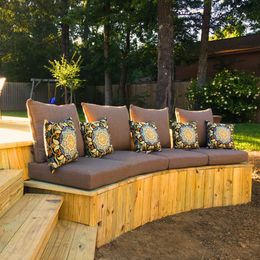 A wooden bench with cushions and pillows on it