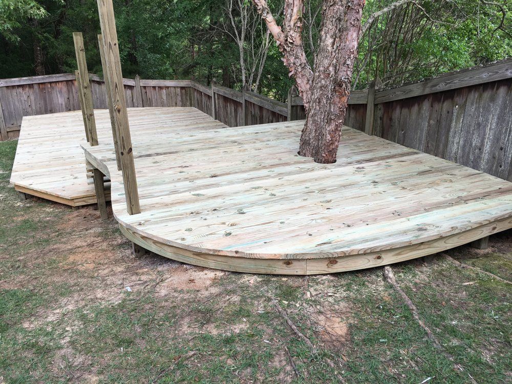 A wooden deck with a tree in the middle of it.