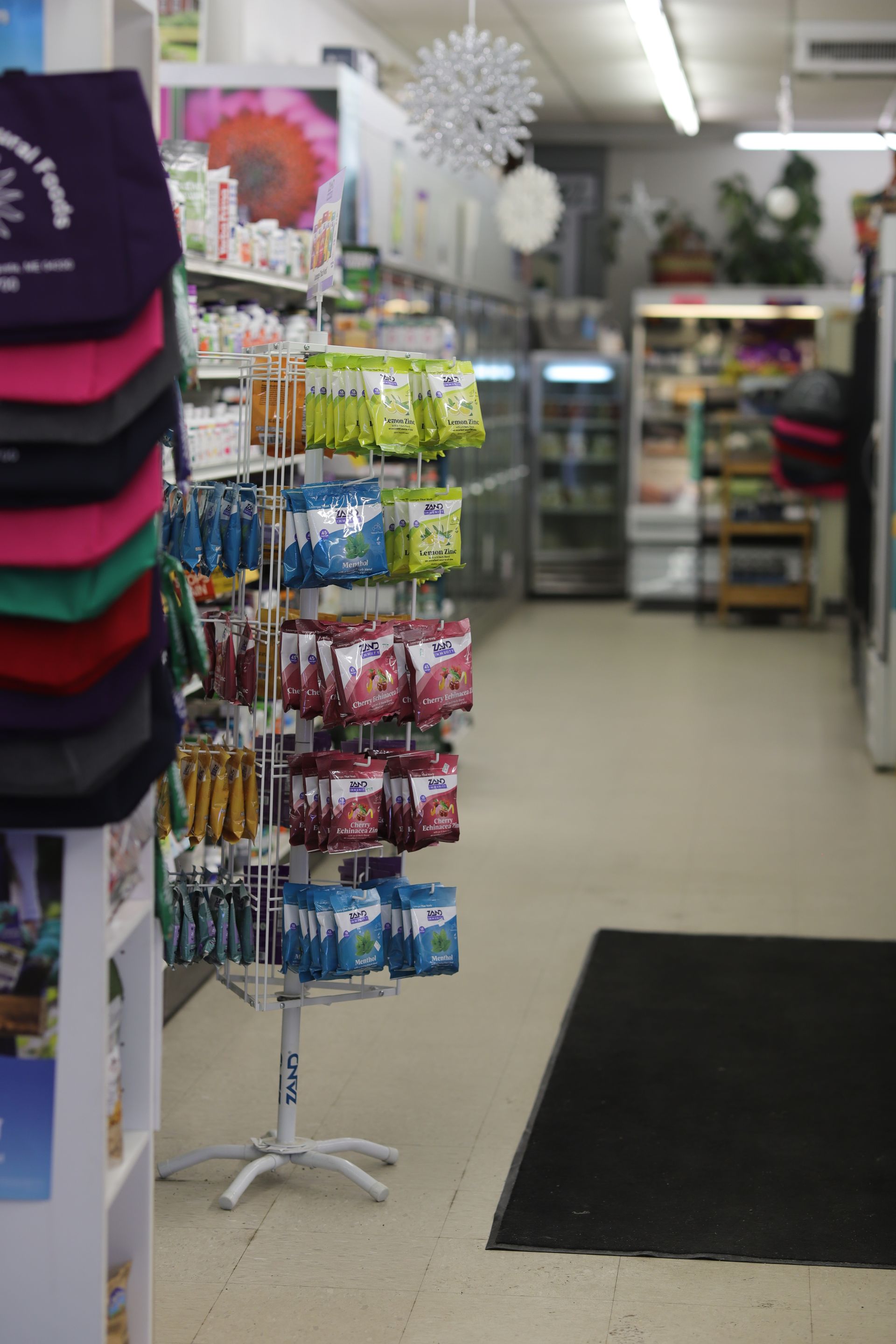 A retail display rack filled with small bags of snacks in a grocery store aisle.