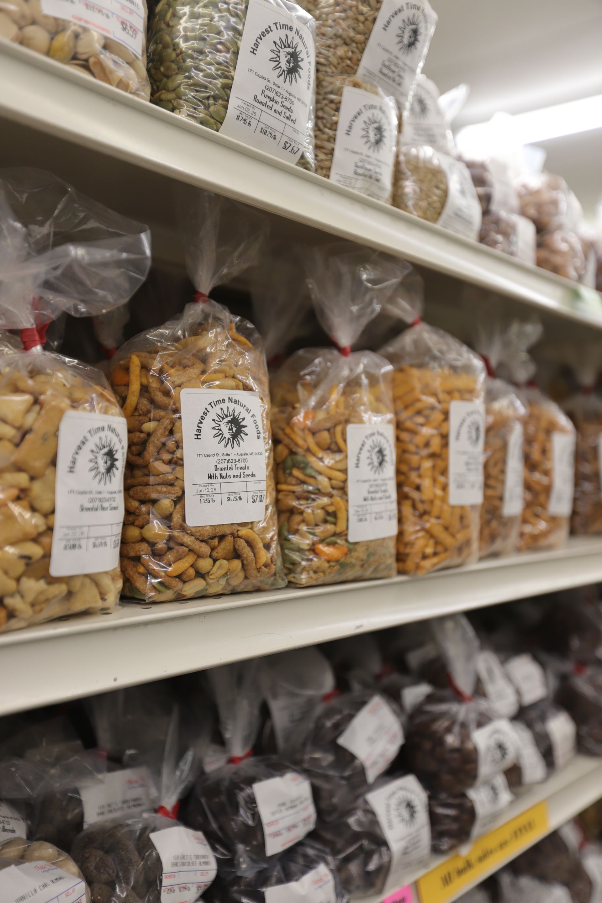 Shelves stocked with clear bags of various snacks and dried goods in a retail setting.