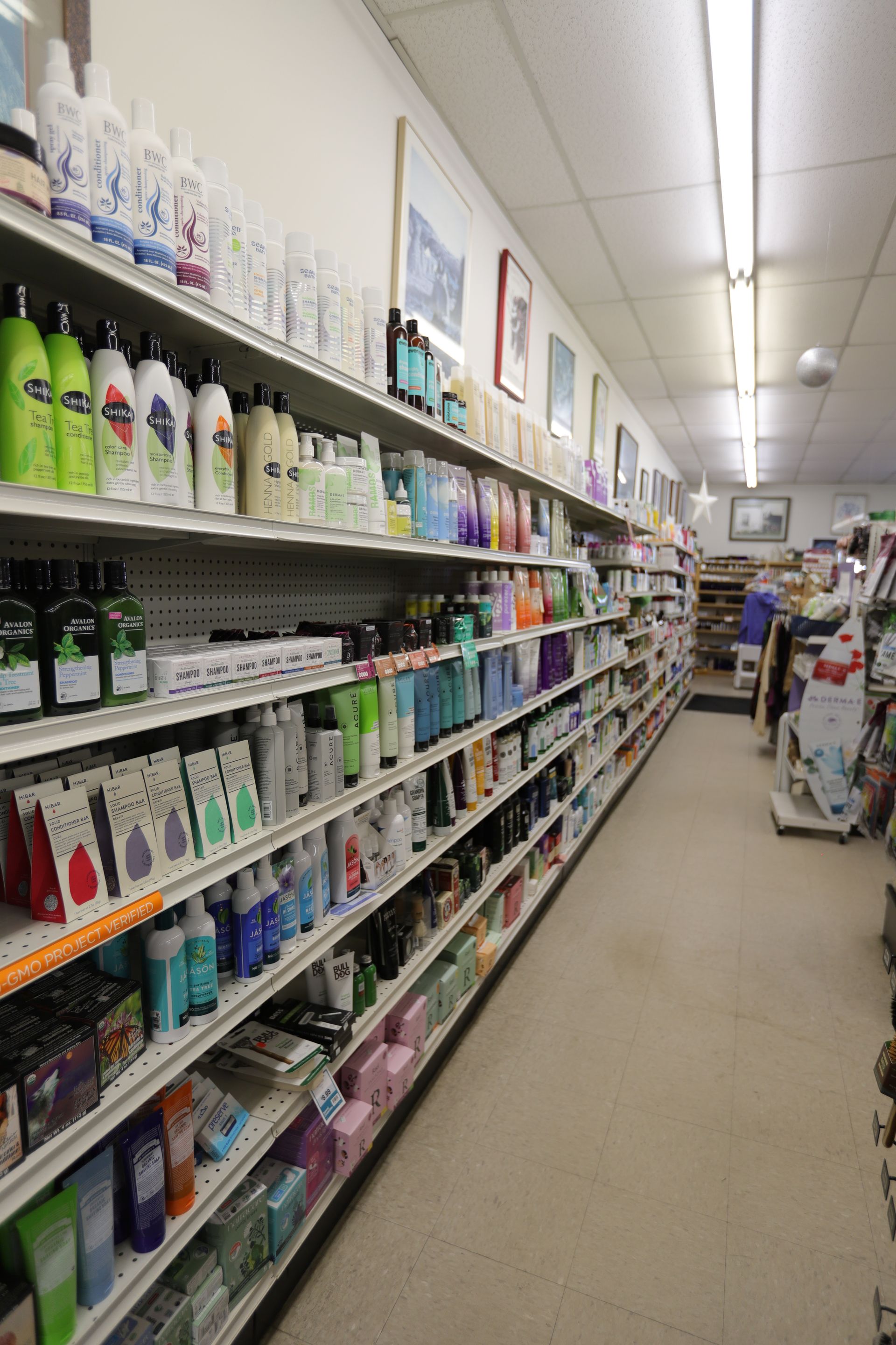 A long aisle in a store with shelves stocked with various personal care and beauty products.