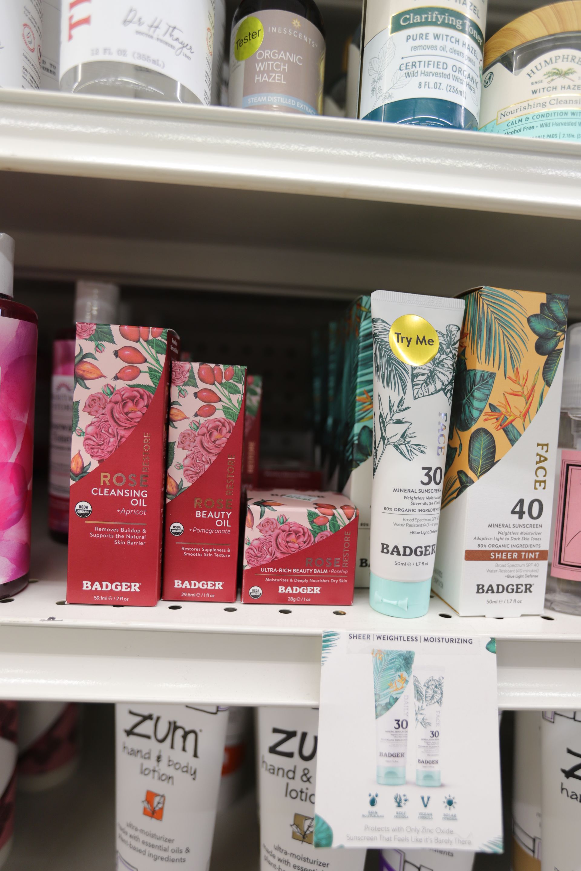 Badger brand sunscreens and skincare products arranged on a retail store shelf.