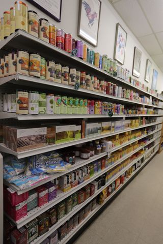 Grocery store shelves stocked with various colorful boxed teas and food items, angled into the distance.