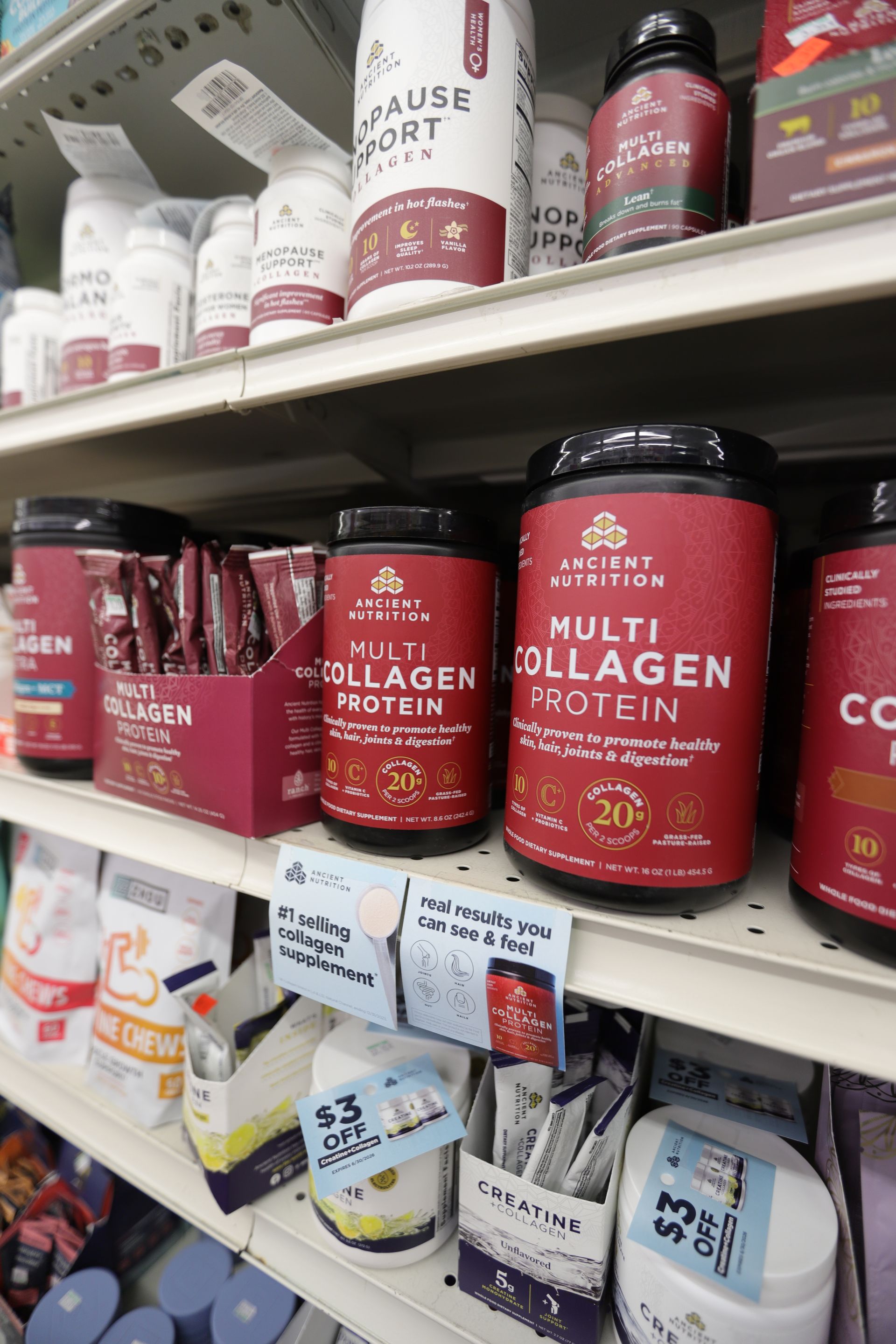 Store shelves filled with various jars and containers of Ancient Nutrition Multi Collagen Protein powder.