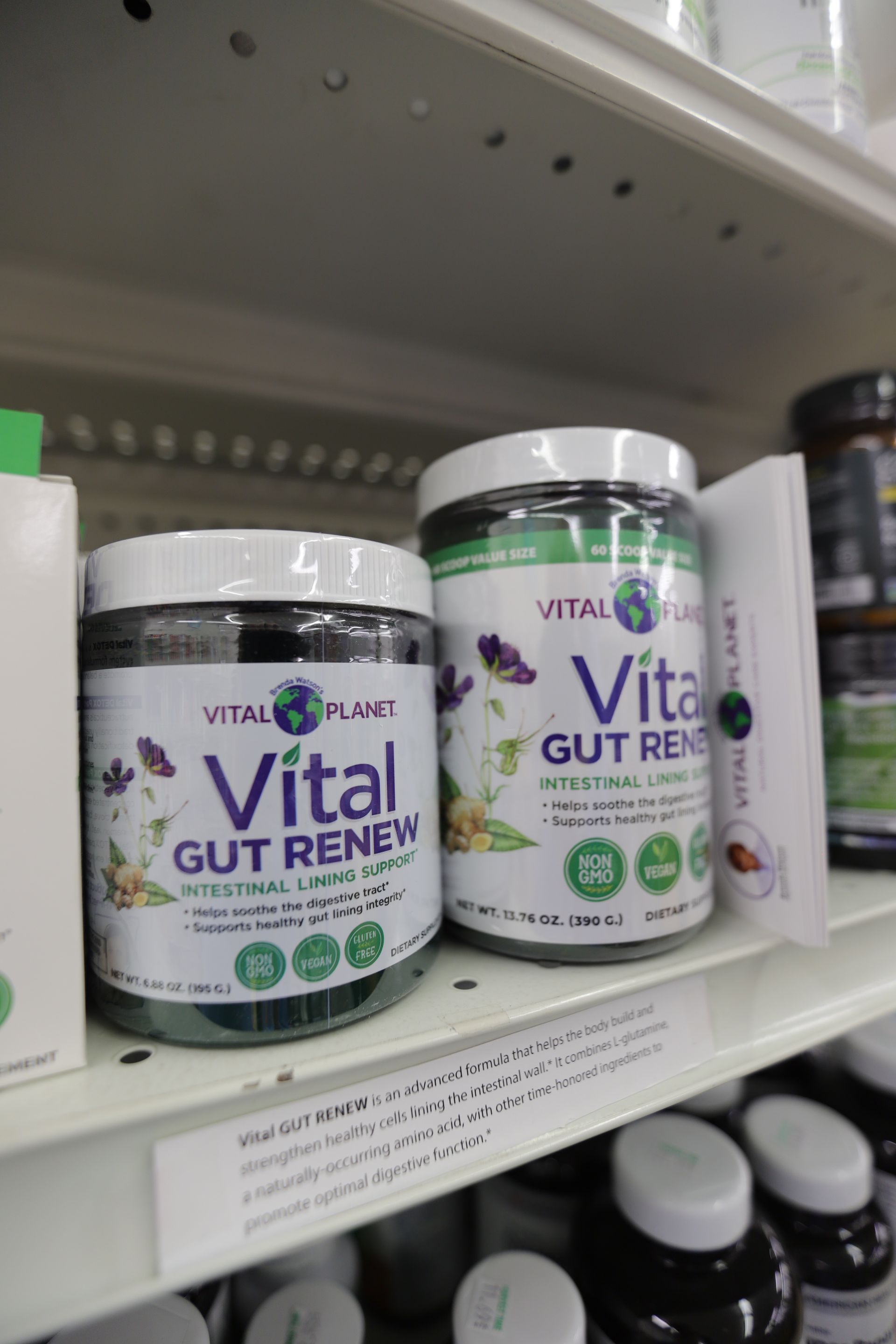 Two jars of Vital Planet Vital Gut Renew supplement on a retail store shelf with other health products.