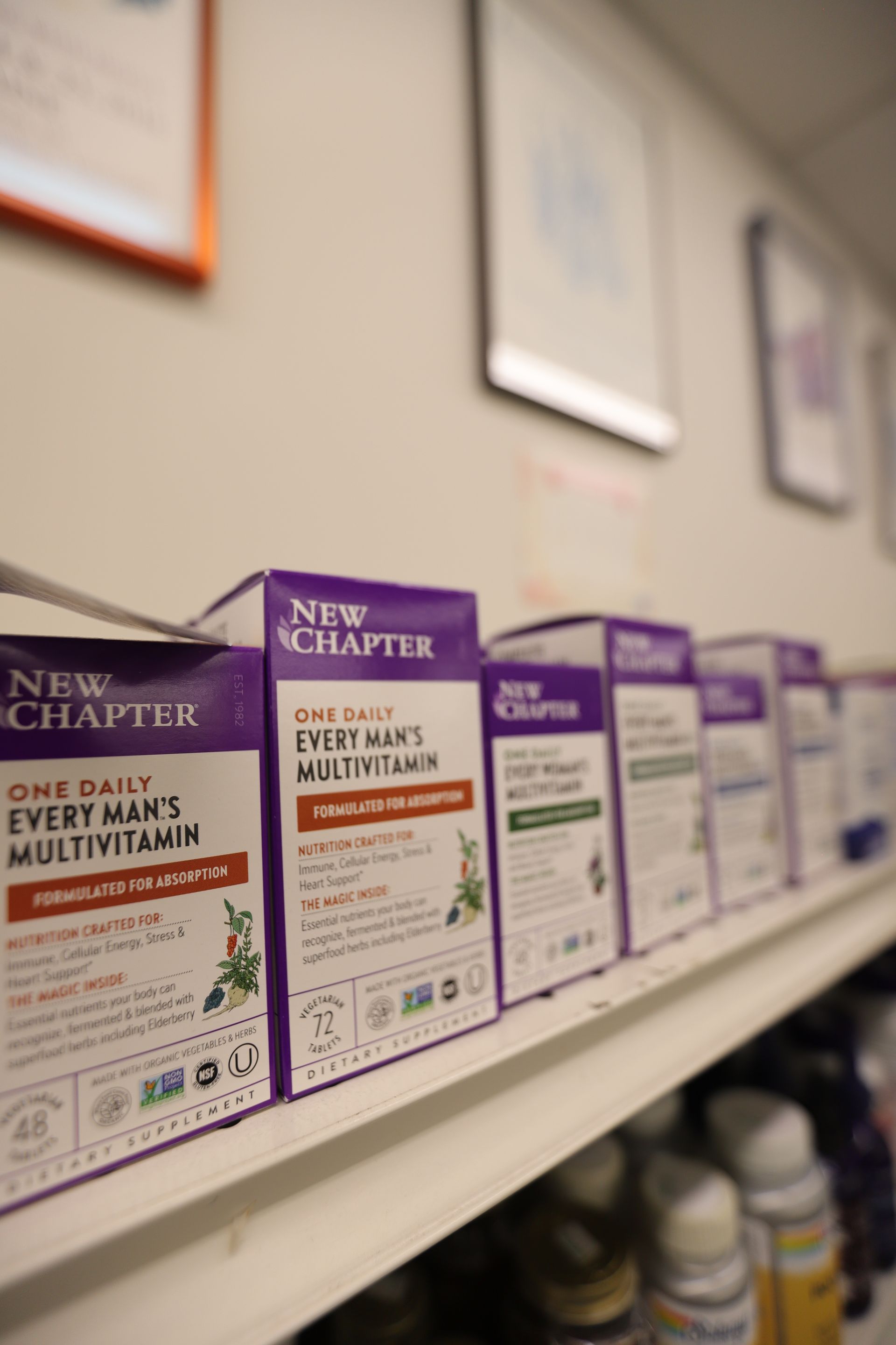 A shelf displaying several boxes of New Chapter Every Man’s Multivitamin in an indoor retail setting.