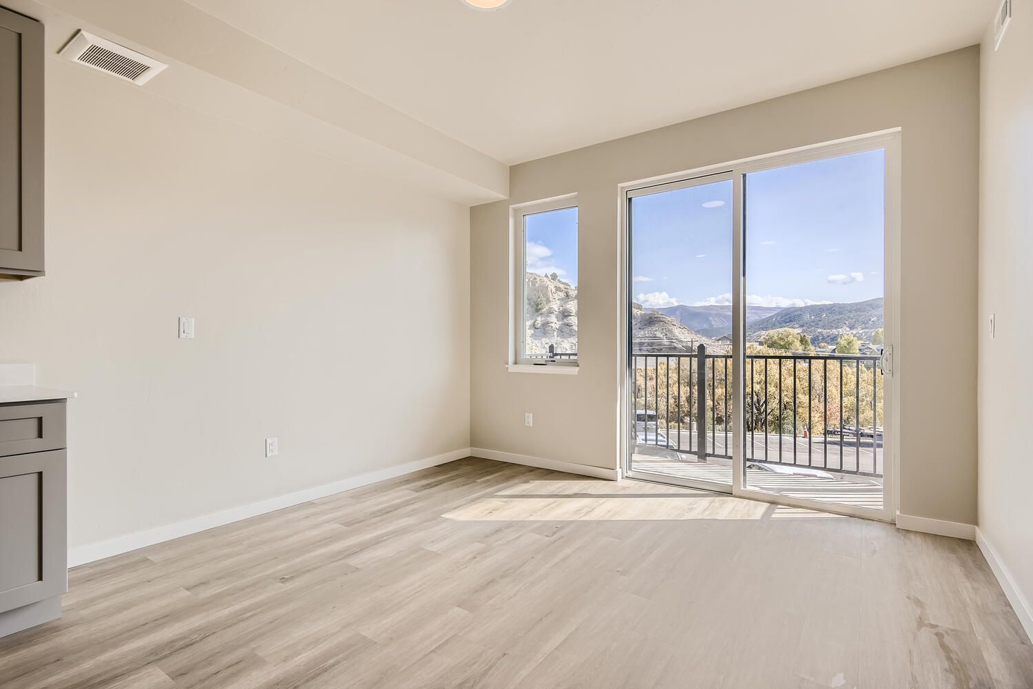an empty room with a sliding glass door leading to a balcony