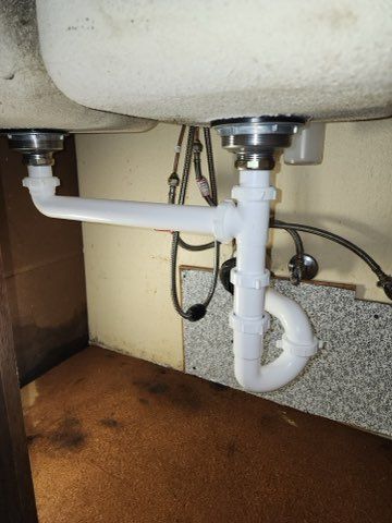A licensed plumber uses a pipe tool for professional drain cleaning on a tiled surface.