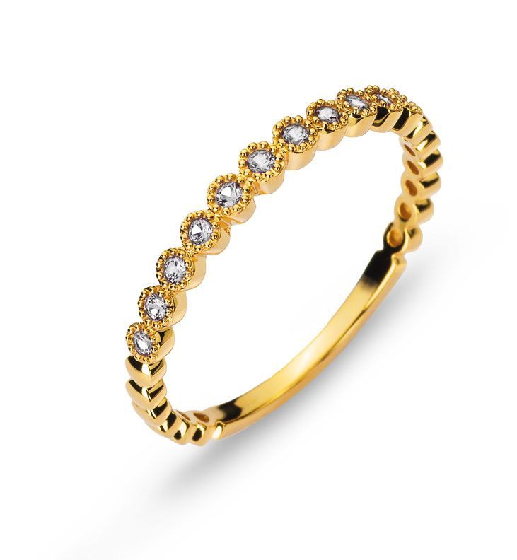 Bague en or ornée d'une rangée de petites pierres précieuses transparentes sur fond blanc