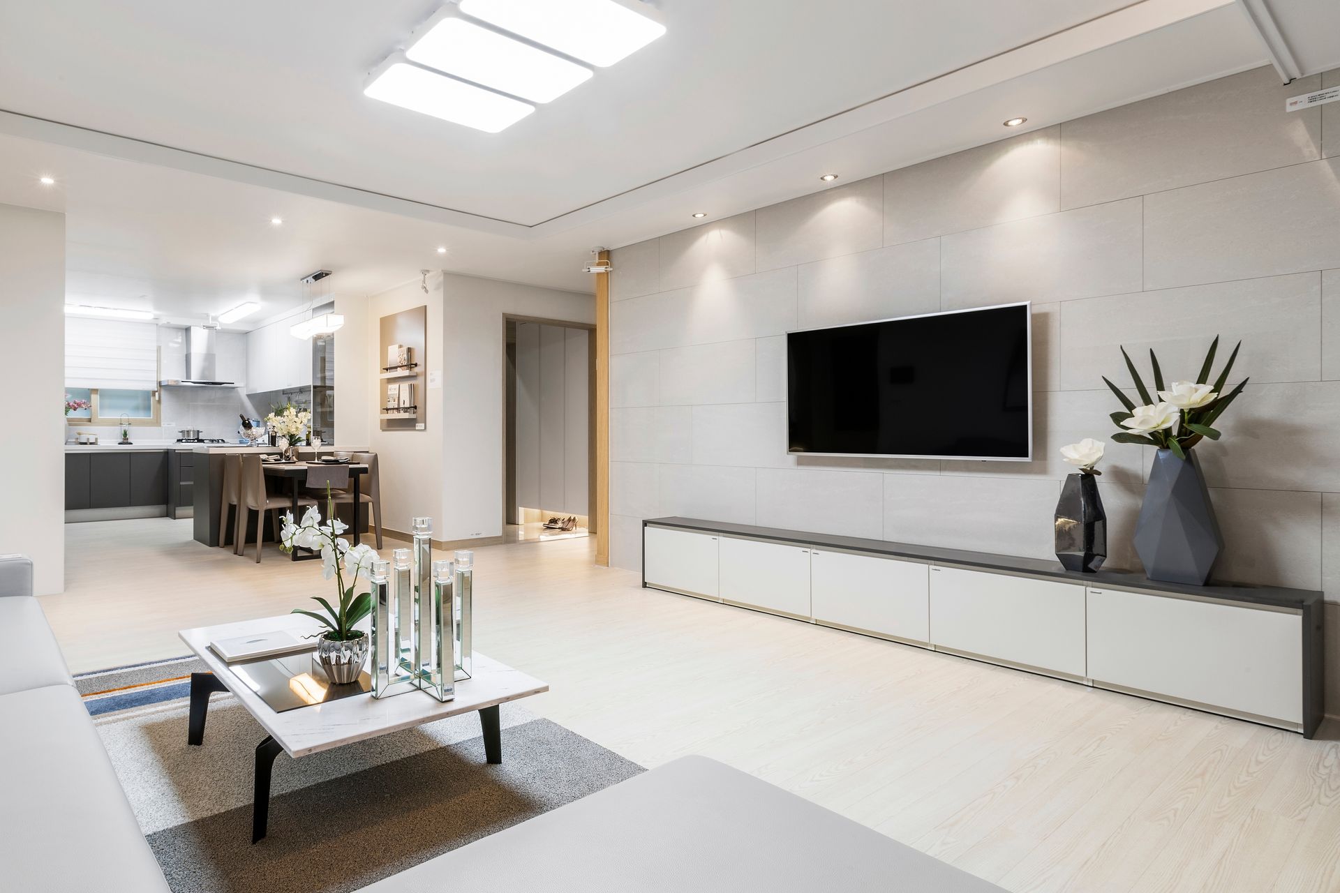 A living room with a flat screen tv on the wall and a coffee table.