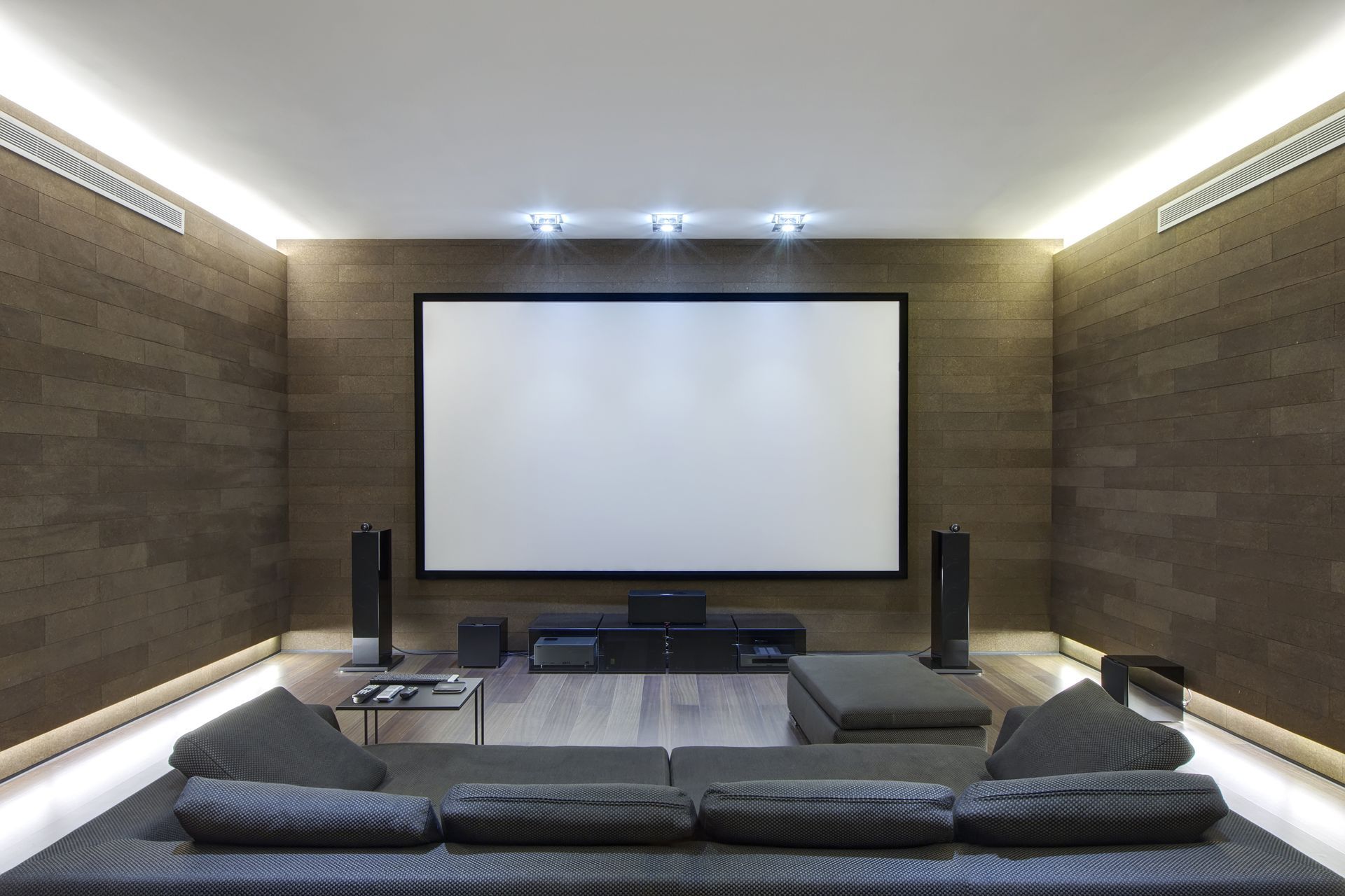 A home theater with a projector screen and a couch.