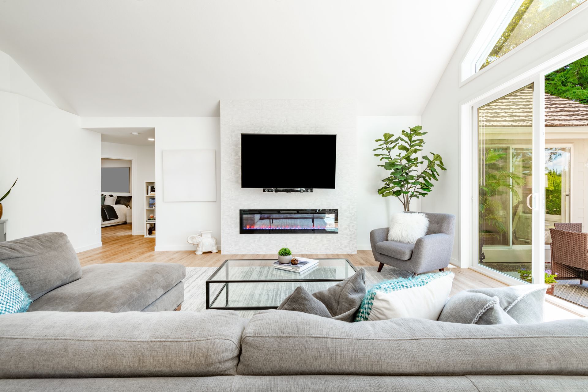 A living room with a couch , chair , coffee table and television.