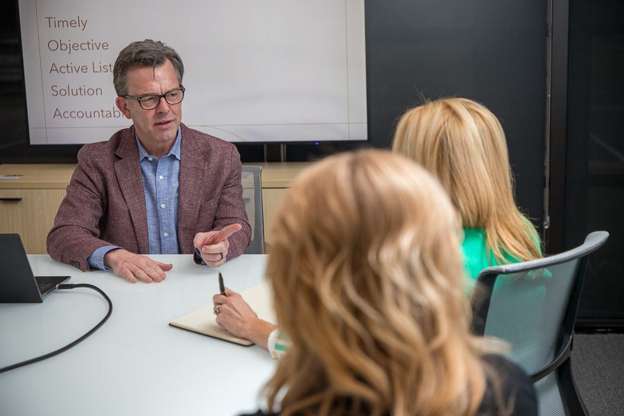 Business meeting with a presenter speaking to two attendees around a conference table