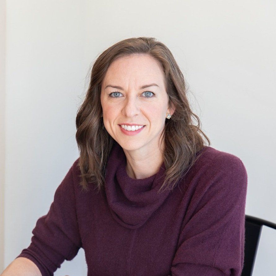 Headshot of a smiling woman in a purple sweater seated against a light background in Zionsville, IN.