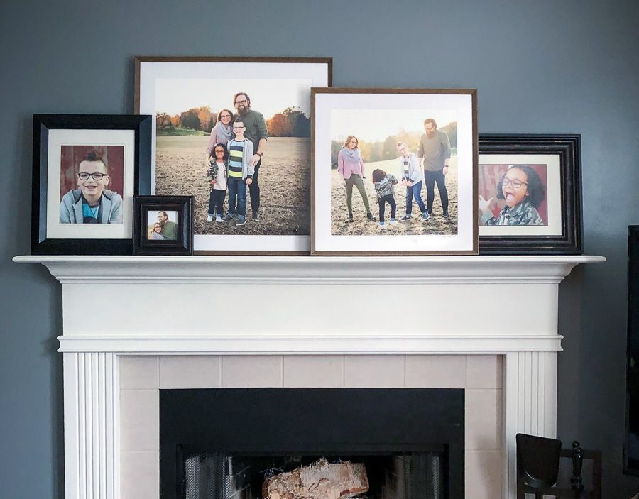 Family photo collage displayed on a white fireplace mantel above a black fireplace in a Carmel, Indiana home.