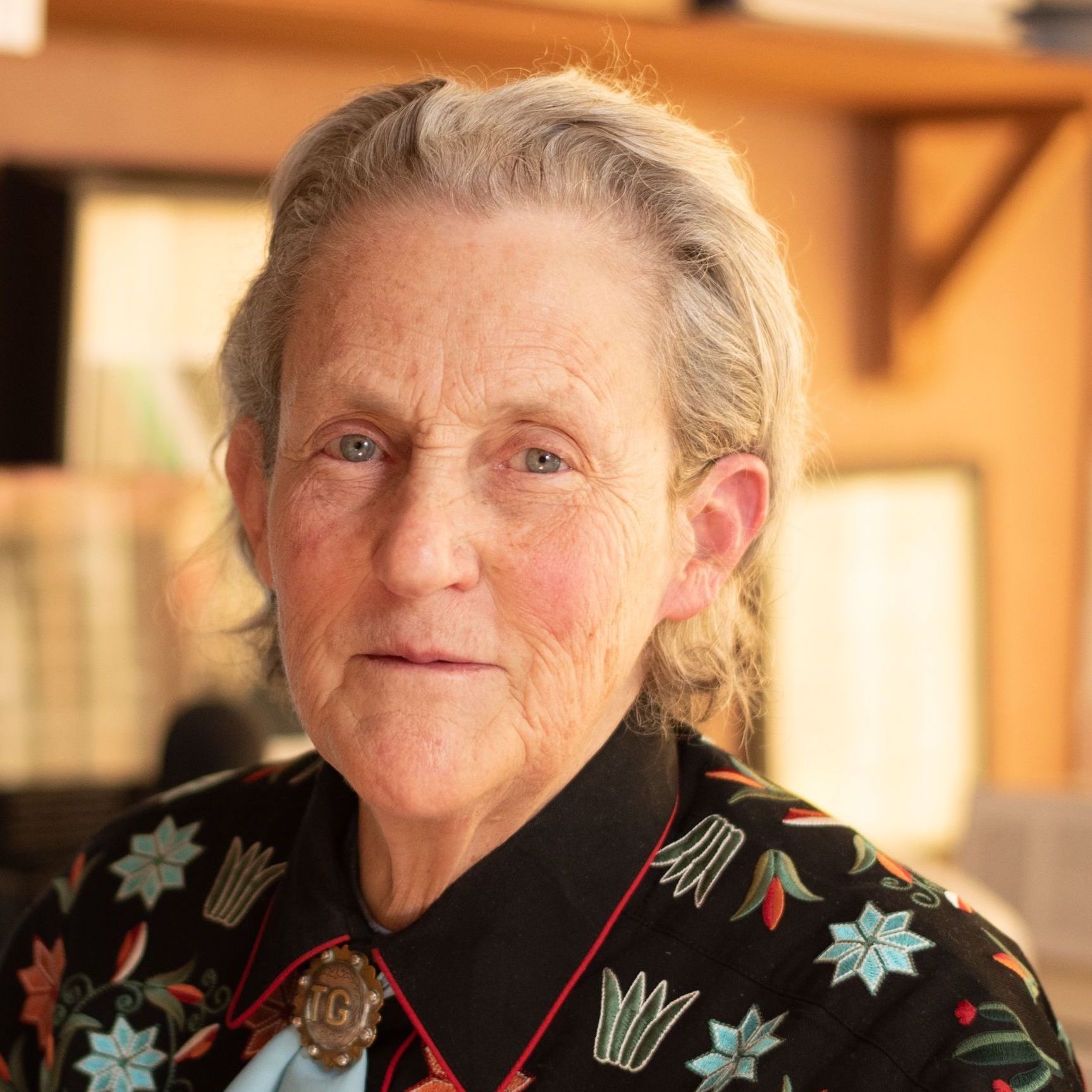 An older woman wearing a black shirt with flowers on it