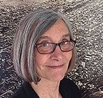 A close up of a woman wearing glasses and a black shirt.