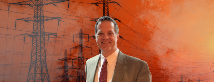 A man in a suit and tie stands in front of power lines