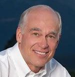 A man in a white shirt is smiling for the camera.