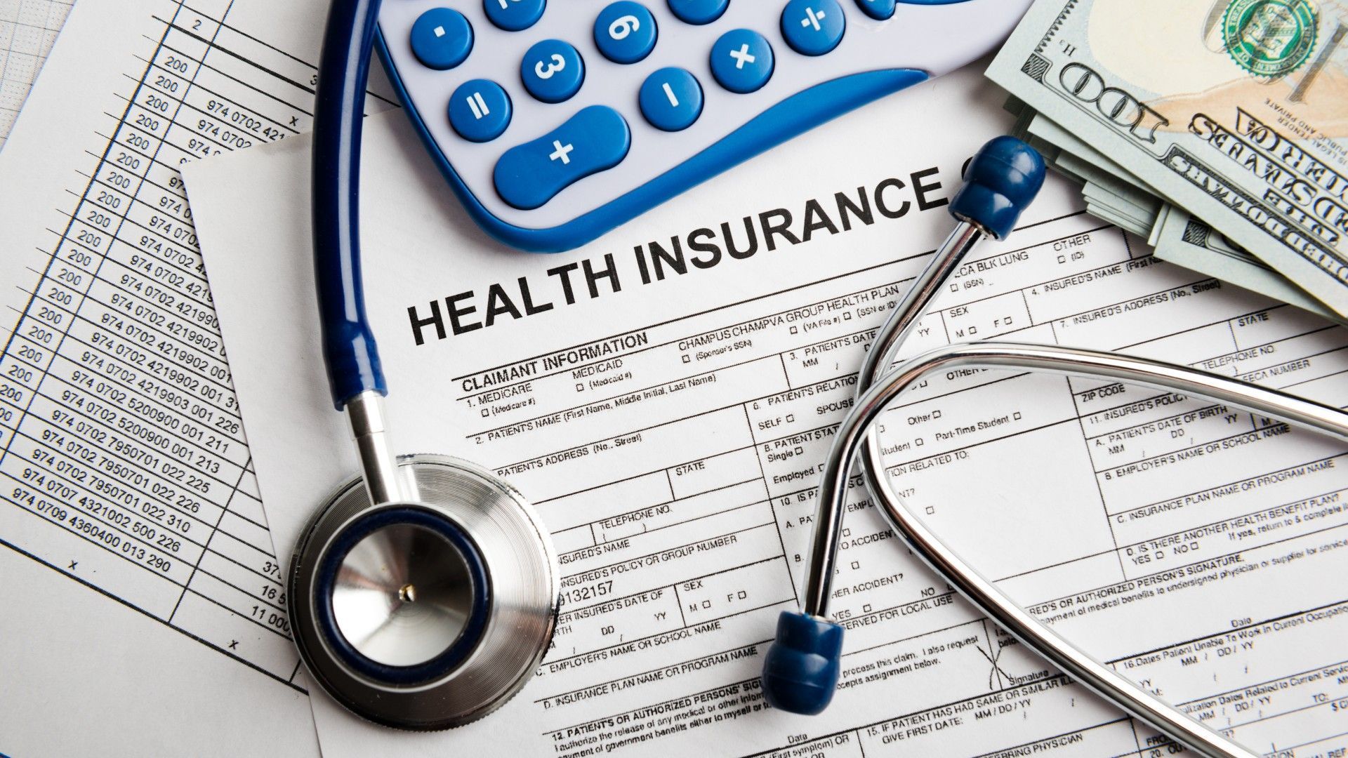 Health insurance form with a stethoscope, calculator, and money.