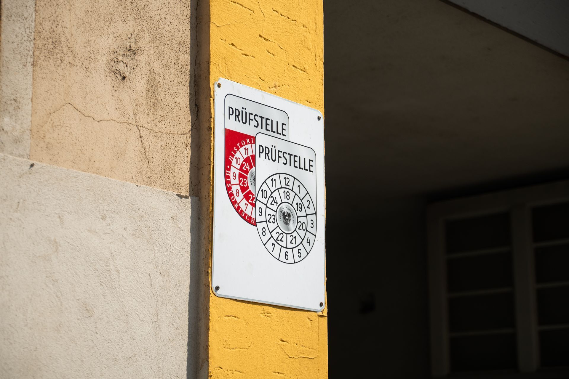 Ein weißes Schild an einem gelben Pfosten mit der Aufschrift „Preisstelle“