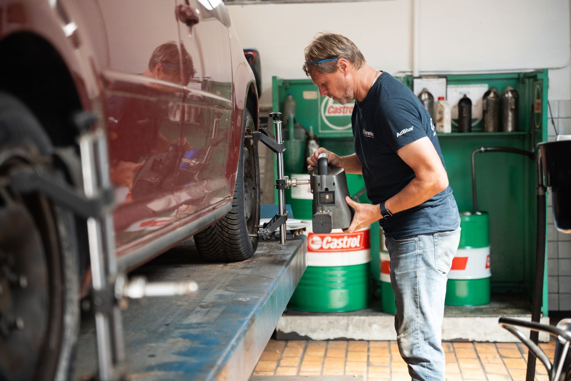 Ein Mann arbeitet in einer Garage an einem Auto.