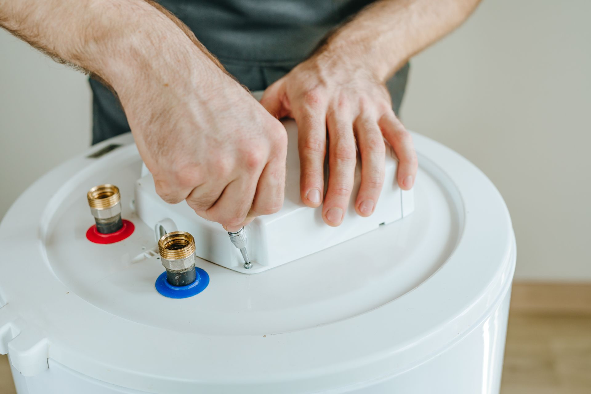 A man is working on a water heater.