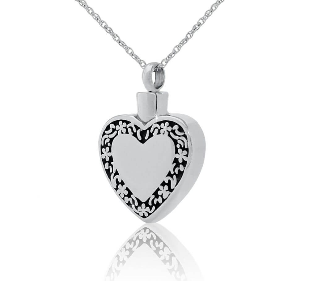 Silver heart-shaped pendant necklace with black decorative border on a white background