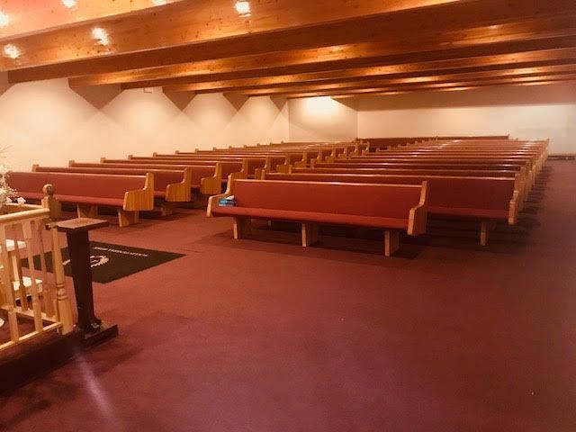 Empty church interior with wooden pews and warm ceiling lights