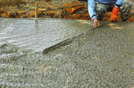 Concrete laborer finishing leveling concrete mix for road in Cheyenne WY