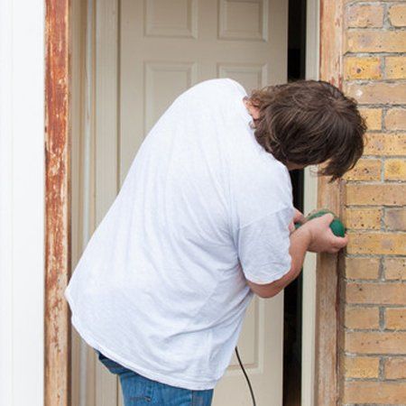 Man sanding down the front door