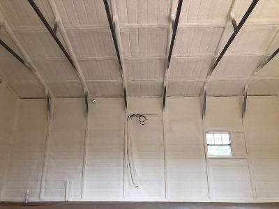 The ceiling of a building with white walls and a window.