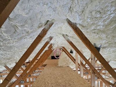 The ceiling of an attic is covered in foam and wooden beams.
