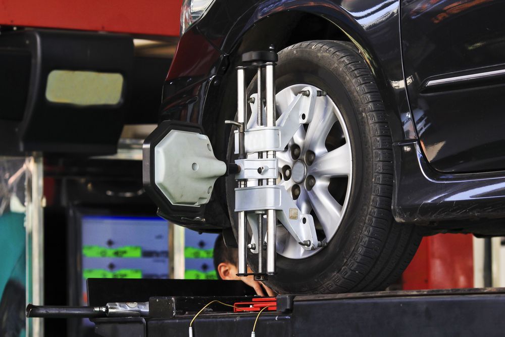A Car Is Being Aligned With A Machine In A Garage — Manning Smash & Auto Repairs In Wingham, NSW