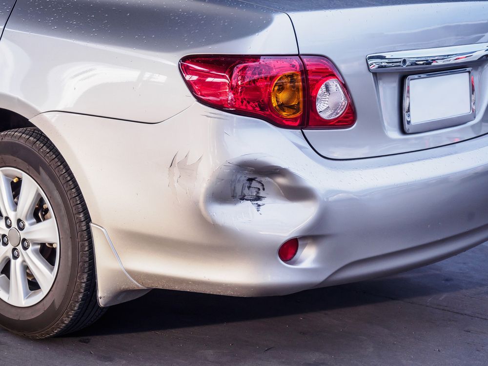 A Silver Car With A Damaged Bumper Is Parked On The Side Of The Road — Manning Smash & Auto Repairs In Wingham, NSW