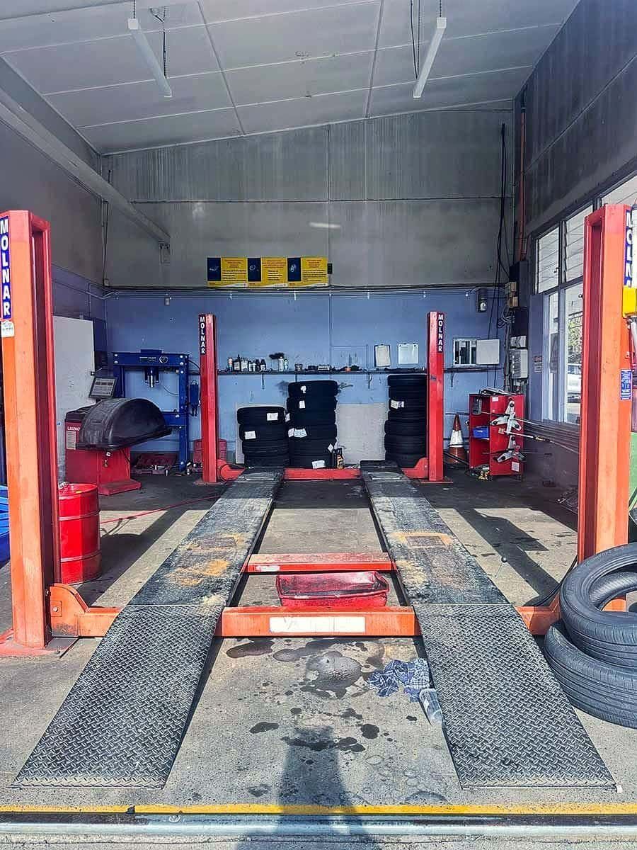 A Garage With A Lift And Tyres In It — Manning Smash & Auto Repairs In Wingham, NSW