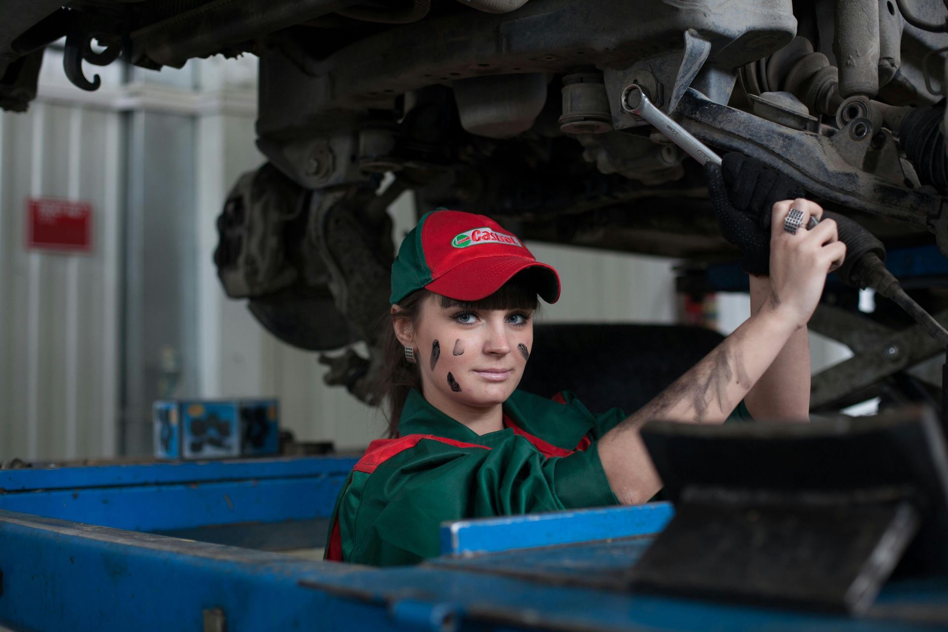 A Woman Is Working On The Underside Of A Car In A Garage — Manning Smash & Auto Repairs In Forster, NSW