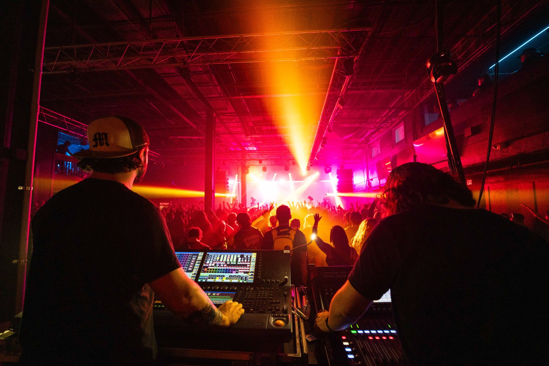 A group of people are standing in front of a stage at a concert.