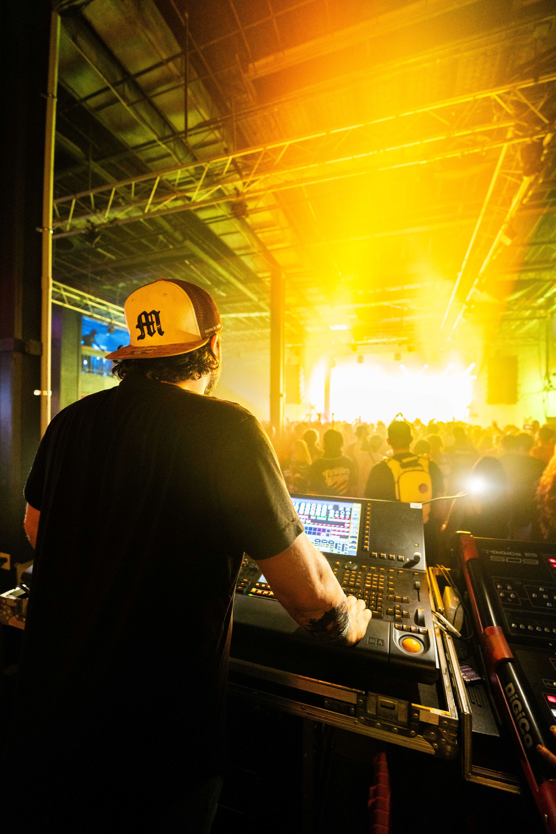A dj wearing a hard hat is playing music in front of a crowd.