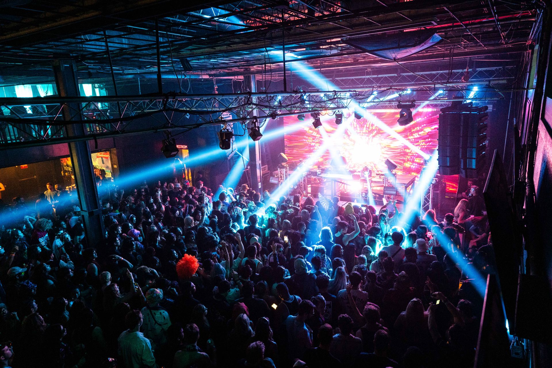 A large crowd of people are watching a band on stage at a concert.