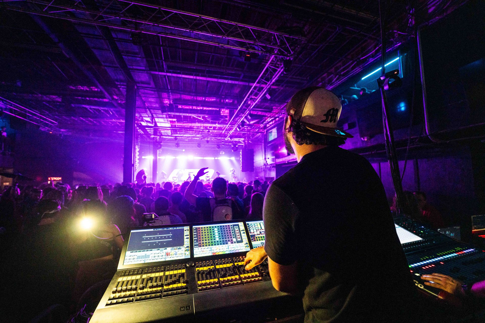 A dj is playing music in front of a crowd at a concert.